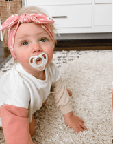 Little girl is wearing a comfortable baby headband for little girls from By Bella Boutique.
